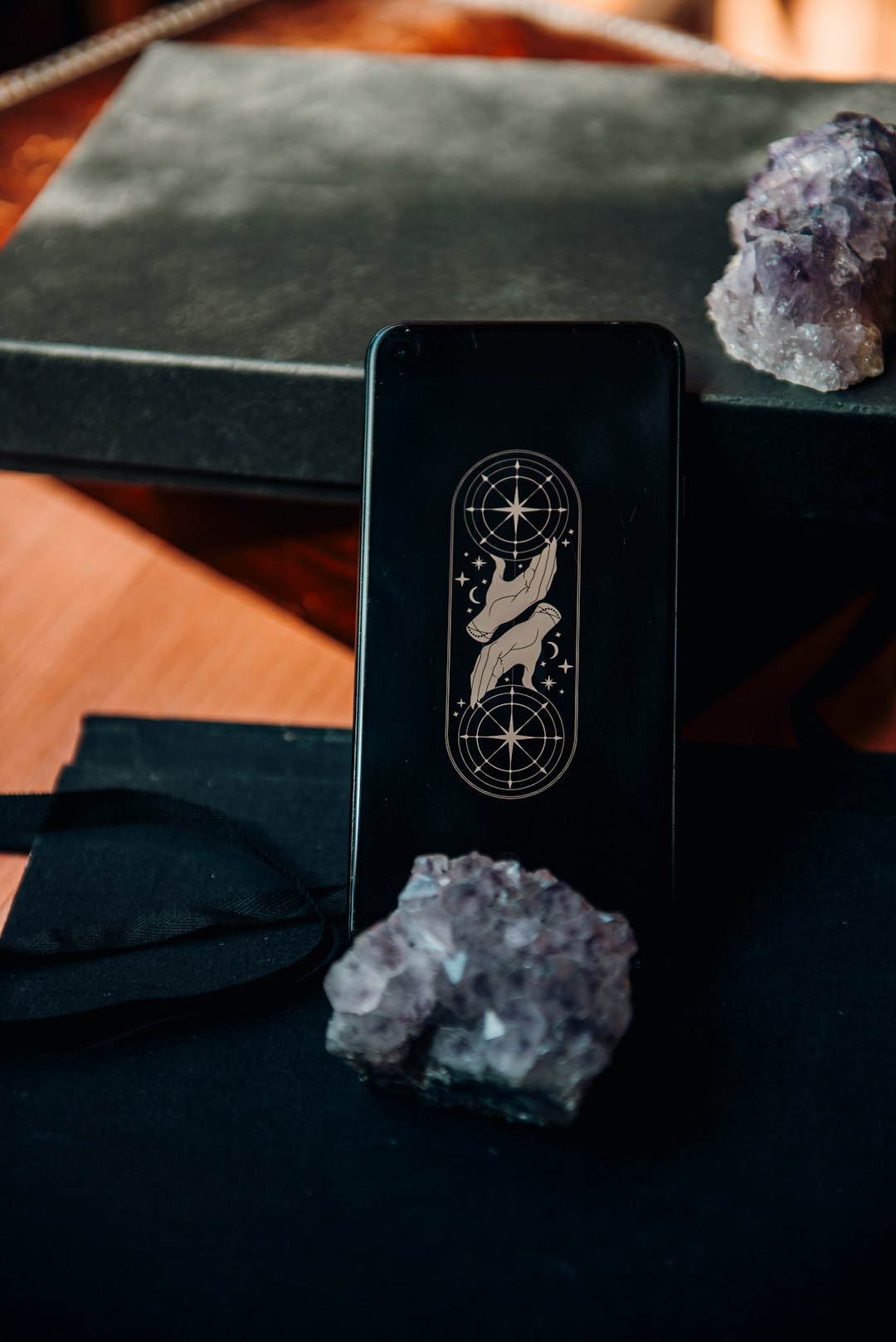 Moody shot of tarot-inspired digital wallpaper on a phone screen. The wheel of fortune is a perfect affirmation screen for any phone. Available here: https://bibelotukshop.etsy.com